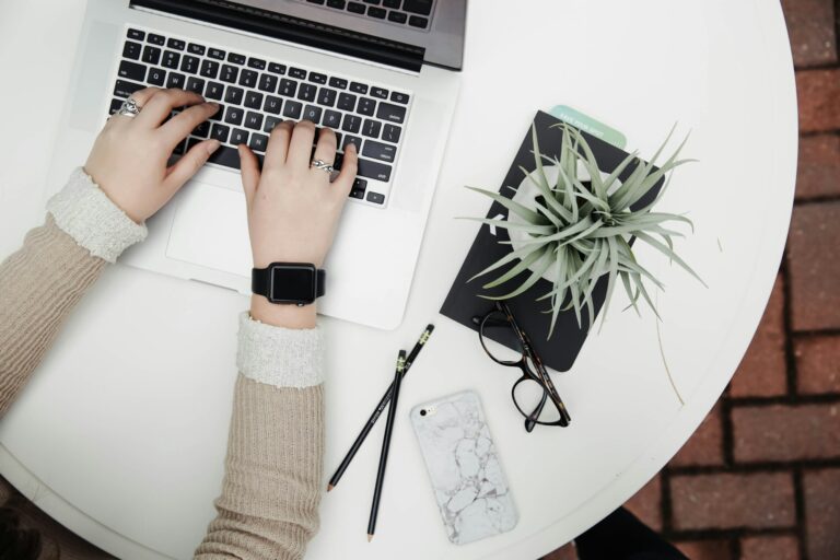 A person working on a laptop beside an aloe plant