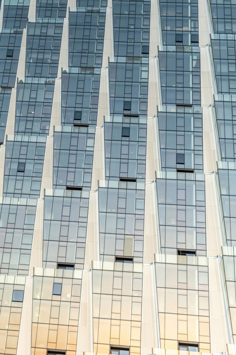 A tall glass building facade with rows of windows