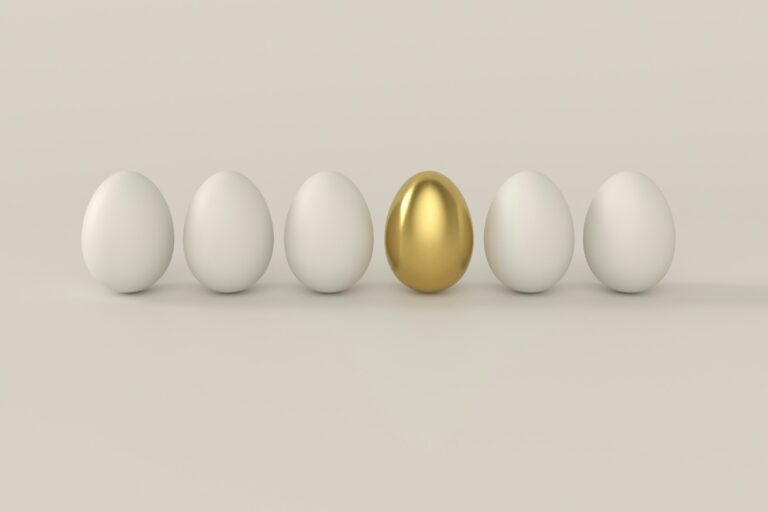 A row of white eggs with one golden egg