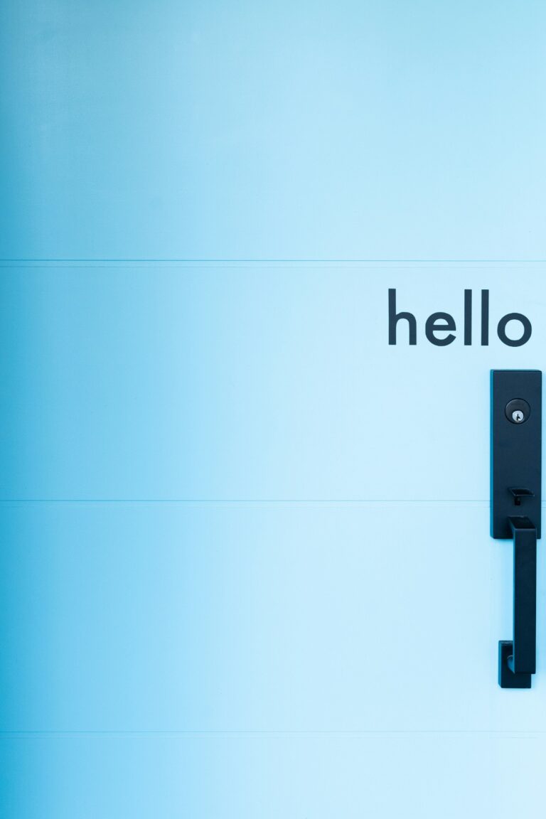 A blue door with the word hello above a black handle