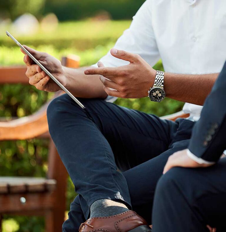 Two people reviewing a tablet outdoors