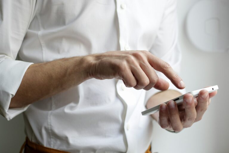 A person holding a smartphone at a desk