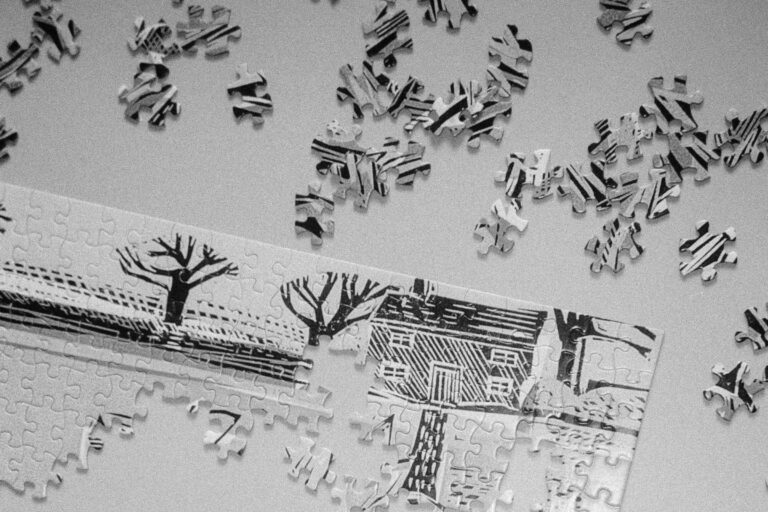 Scattered puzzle pieces beside a partially assembled puzzle