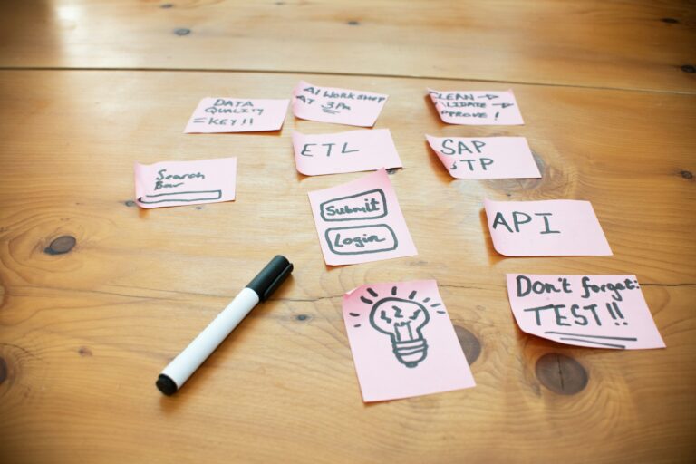 Sticky notes with words and sketches spread across a wooden table
