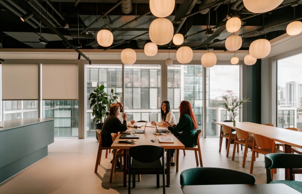 Four colleagues talking around a table in a bright office