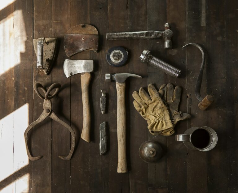 Vintage work tools laid out on dark wooden planks