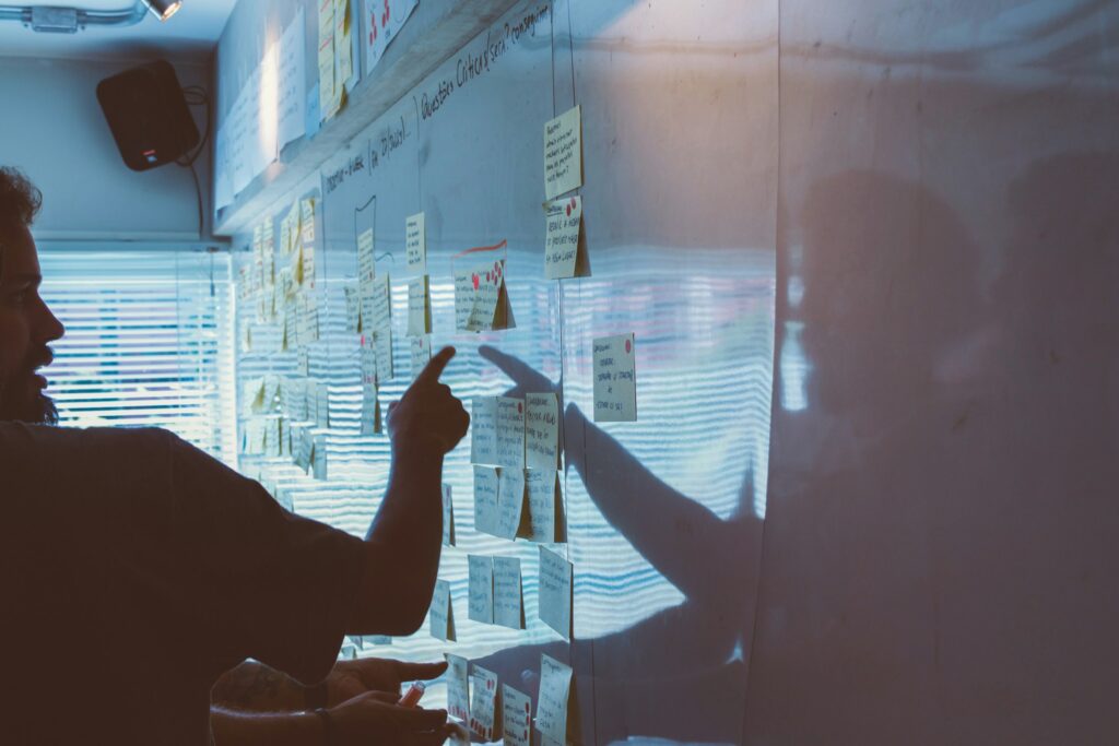 Person pointing at paper on a wall